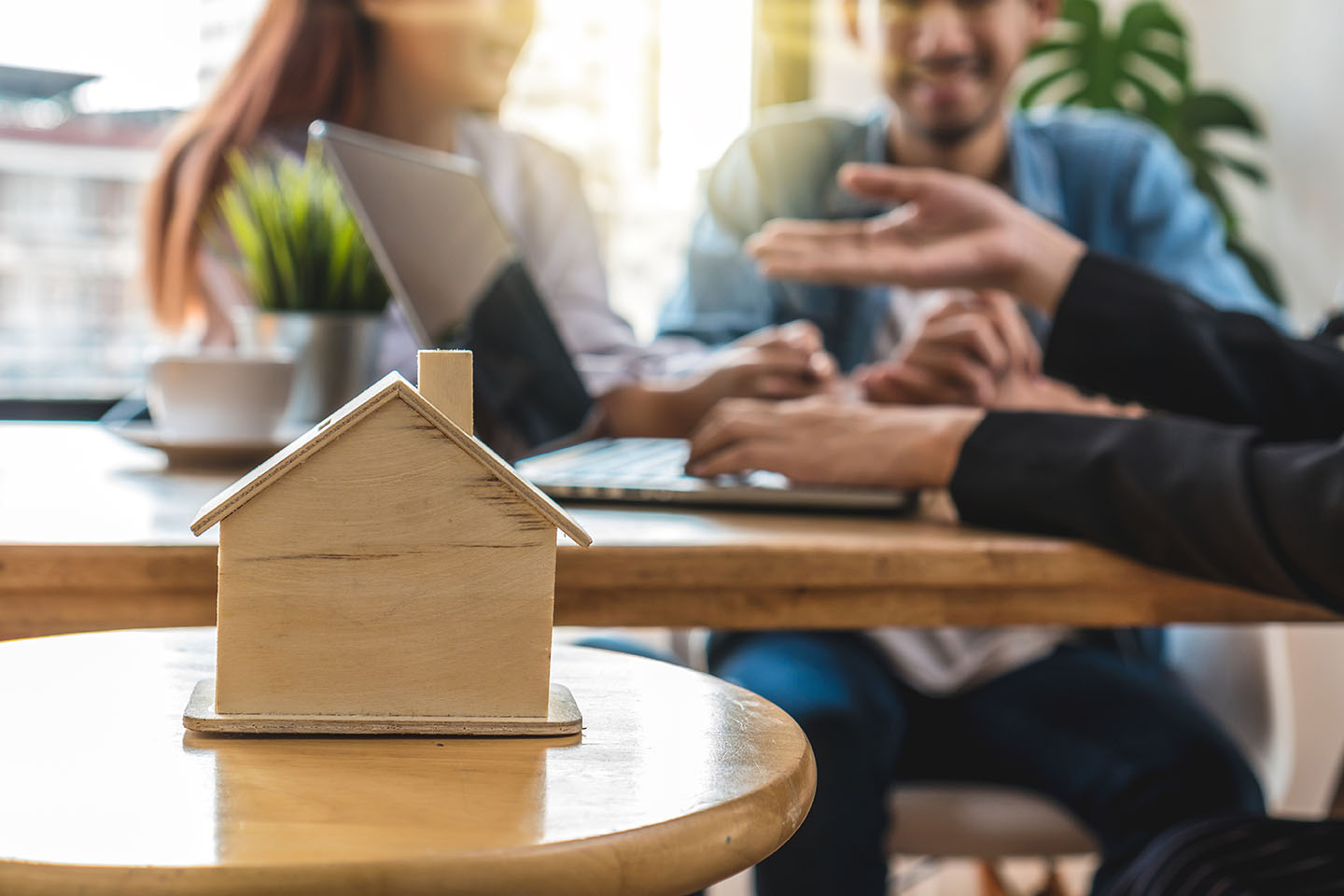 decorative stock image of people talking with a wooden housing in the forefront